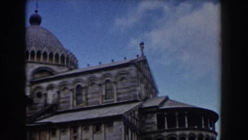 1959 Pisa Cathedral view with the dome, striped stonework, and arched windows framed by dark film borders.