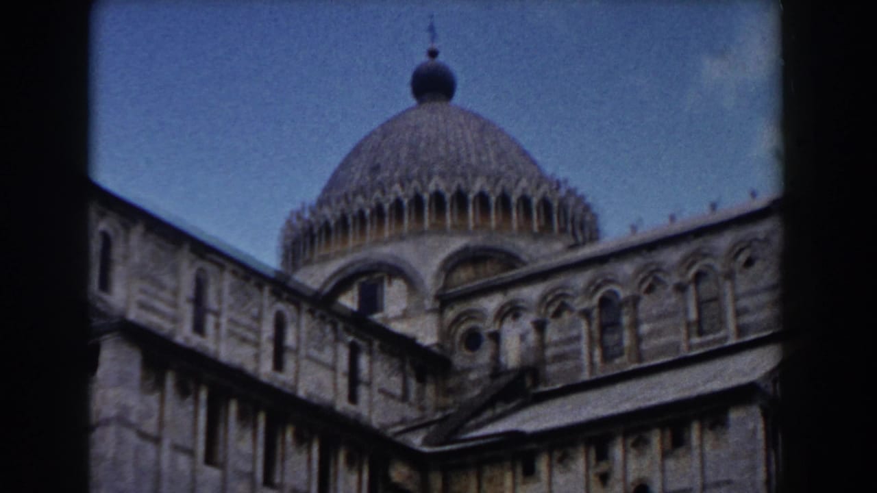 1959 8mm view of Pisa Cathedral with a large dome, arched windows, and patterned stonework beneath a clear sky.