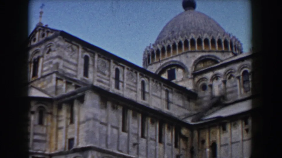 1959 Pisa Cathedral view showing the side wall, dome, arched openings, and Romanesque stone patterning on 8mm film.