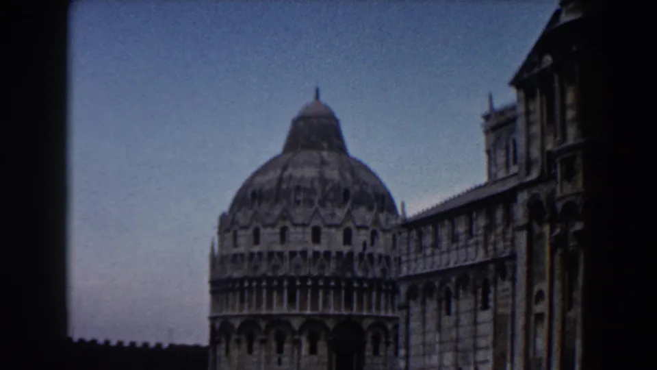 1959 Pisa landmark view showing the Baptistery dome and Cathedral facade, with strong dark edge from the 8mm frame.