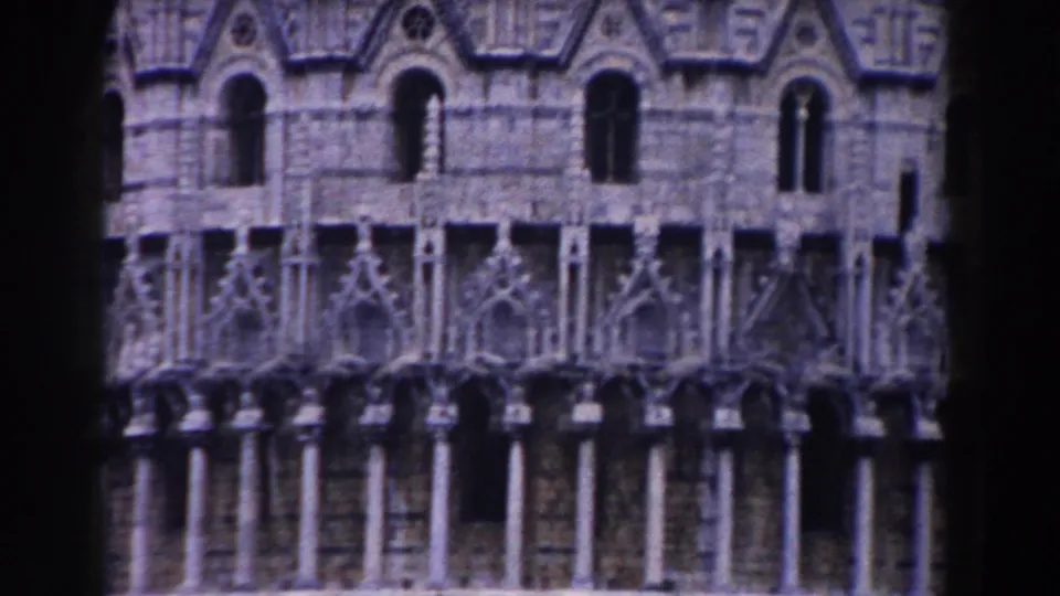 1959 Pisa travel footage frames ornate arched windows, columns, and carved stonework on the landmark facade.