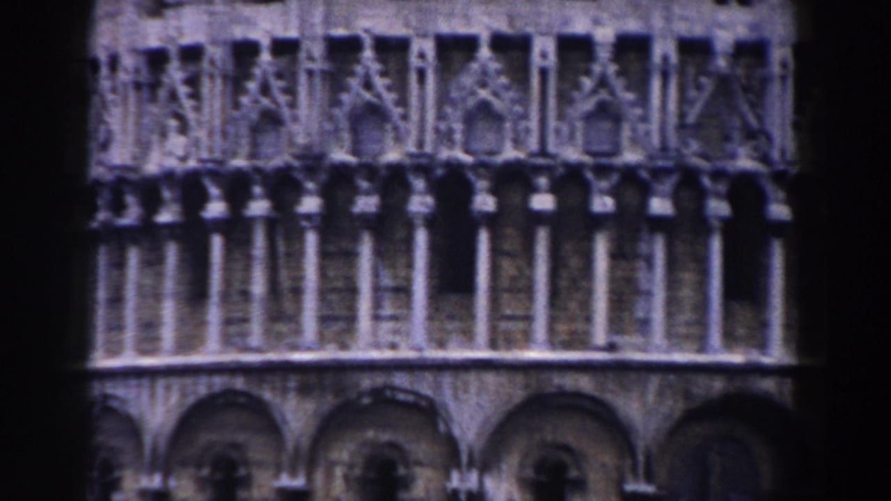 Pisa, Italy landmark architecture in a 1959 8mm home-movie frame, showing carved stone galleries, columns, and arched openings.