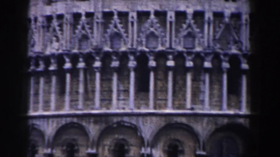 Pisa, Italy landmark architecture in a 1959 8mm home-movie frame, showing carved stone galleries, columns, and arched openings.