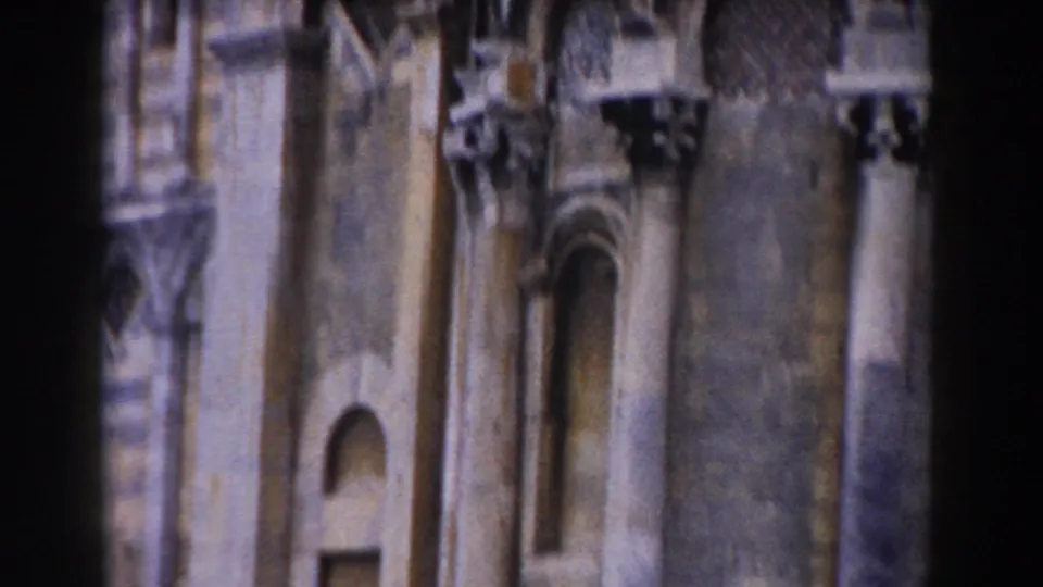 Pisa architectural detail in 1959 home-movie footage, with lower arcades, columns, masonry surfaces, and a small recessed opening.