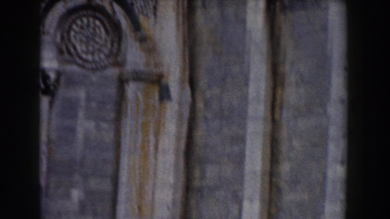 Stone cathedral facade with circular rose window and arched architectural details.