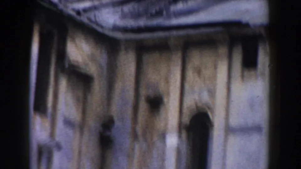 Vintage 8mm view in Pisa showing weathered church stonework, a curved roofline, and a narrow arched opening.