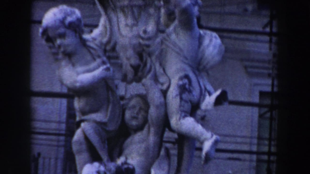 Stone cherubic figures on a classical public sculpture with dark film borders.