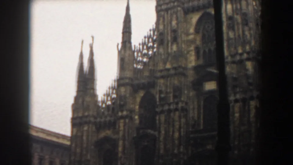 Milan Cathedral's spires and upper facade fill the frame in soft, grainy 1959 8mm footage.
