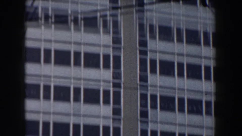 1959 Pisa frame showing the upper part of a modern multi-story building with repeated window rows and vertical facade lines.