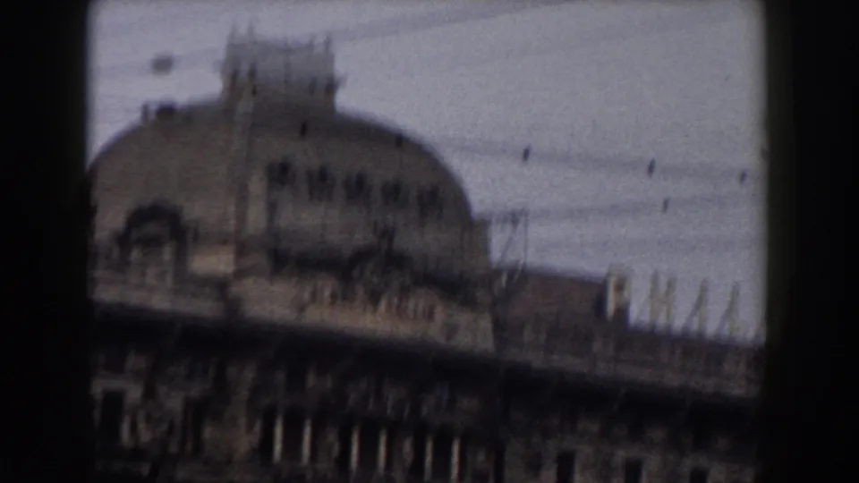 Home-movie view in Pisa showing a distinctive domed roofline, overhead wires, and soft architectural detail.