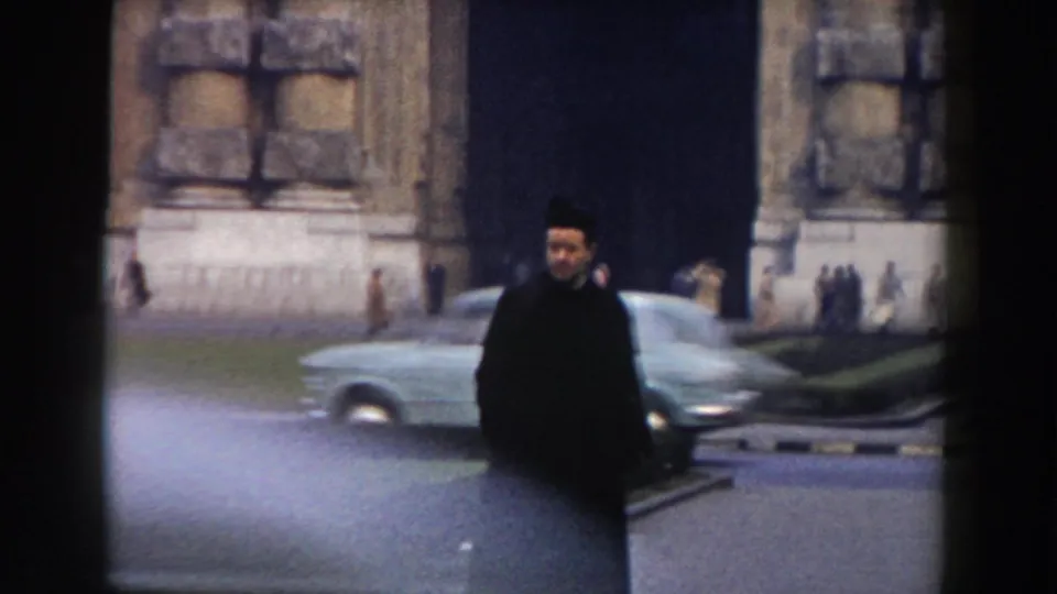 In 1959 Pisa, a traffic officer stands near a large stone structure while a mid-century car moves through the foreground.