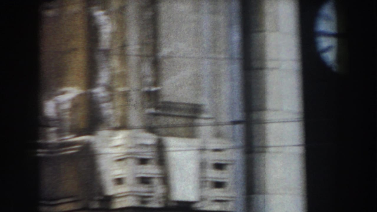 Soft 8mm view of stone columns and facade details along a historic building.