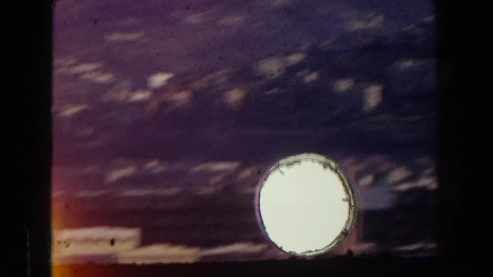 1959 Pisa 8mm strip detail with one bright sprocket opening, dark frame divider, faded color, and surface wear.