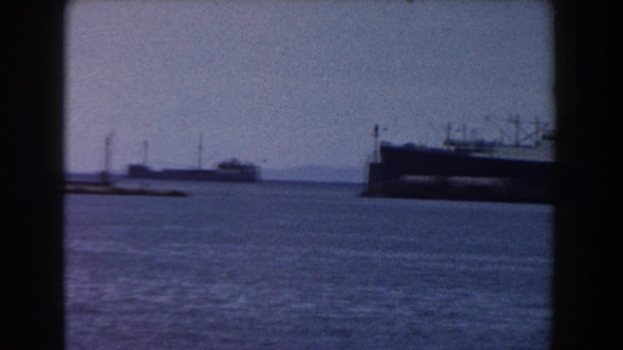 Distant harbor water with part of a large ship near the right edge.