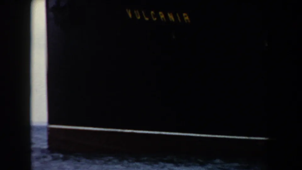 1959 Pisa-area home-movie frame with dark exposure, faint lettering, a bright edge, and indistinct foreground detail.