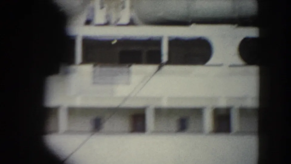 1959 Pisa-area travel frame showing a white ship-like surface with rows of openings, partly blocked by a dark foreground shape.