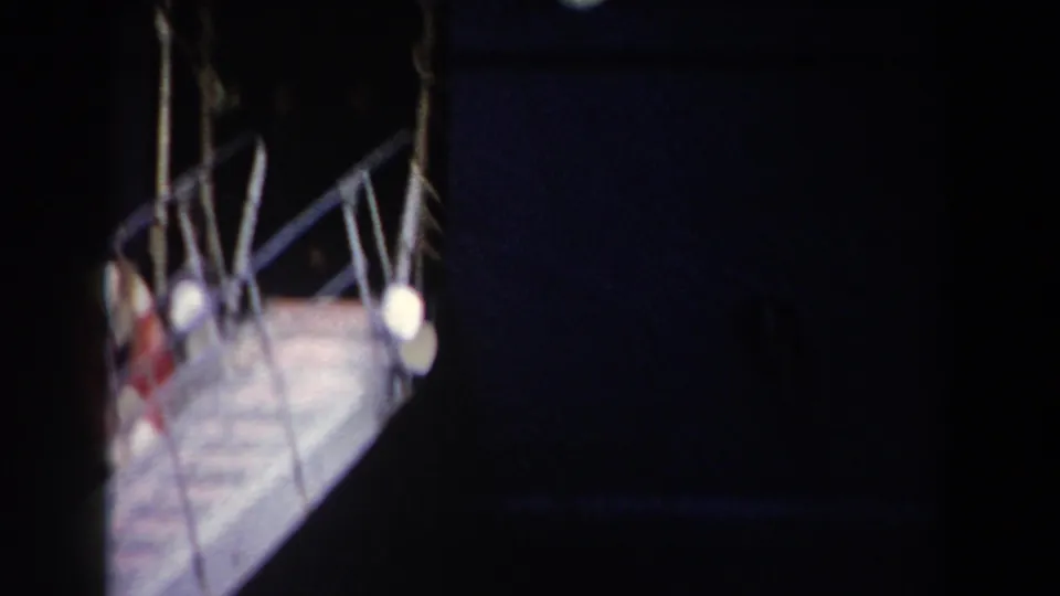 Passengers and railings are partly obscured as the metal gangway recedes beside the dark ship in 1959 Pisa, Italy footage.