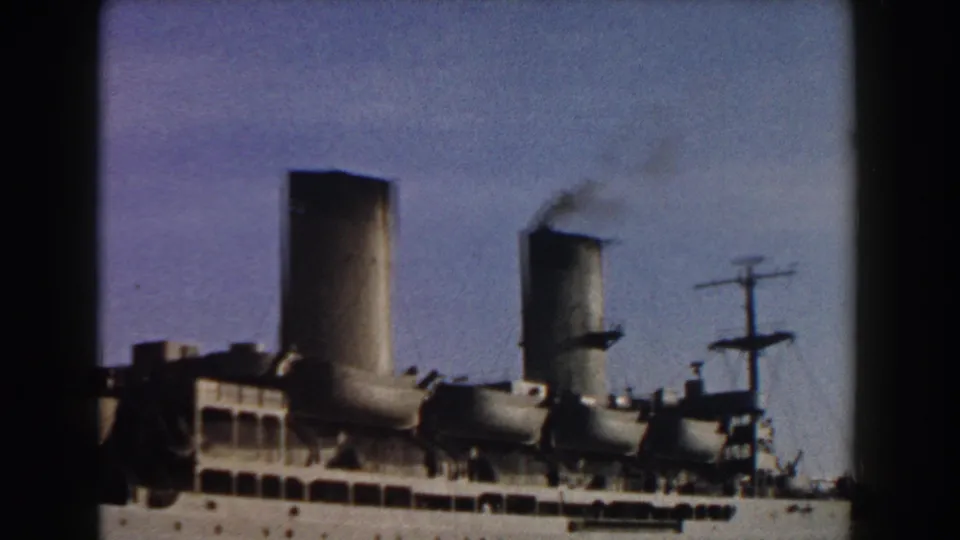 1959 Italy 8mm frame showing two ship funnels, mast rigging, deck details, and faint smoke from one funnel.