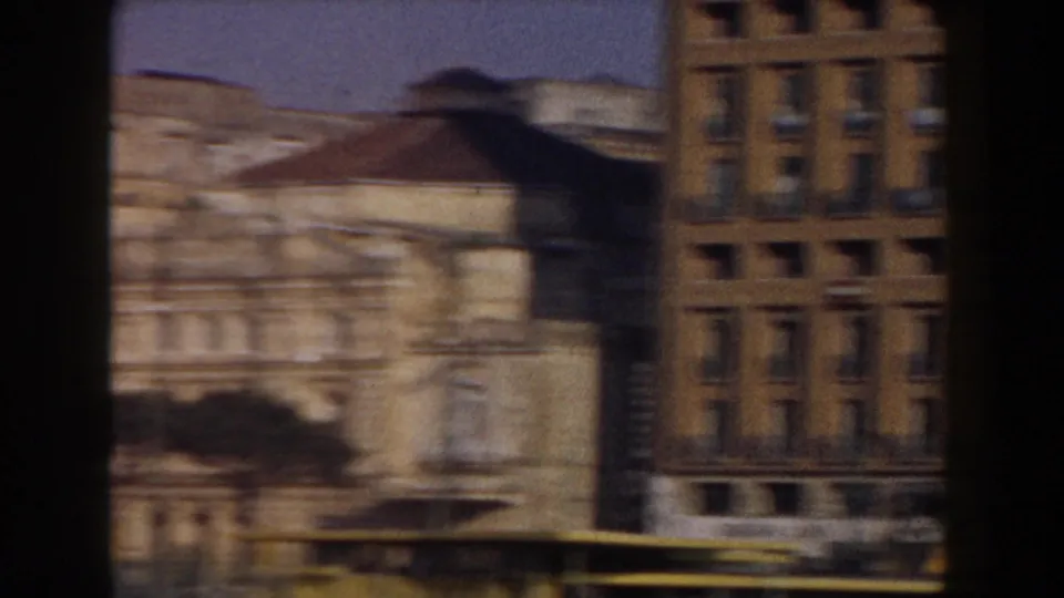 1959 Pisa city view with ornate facades and worn masonry seen from a moving 8mm home-movie viewpoint.