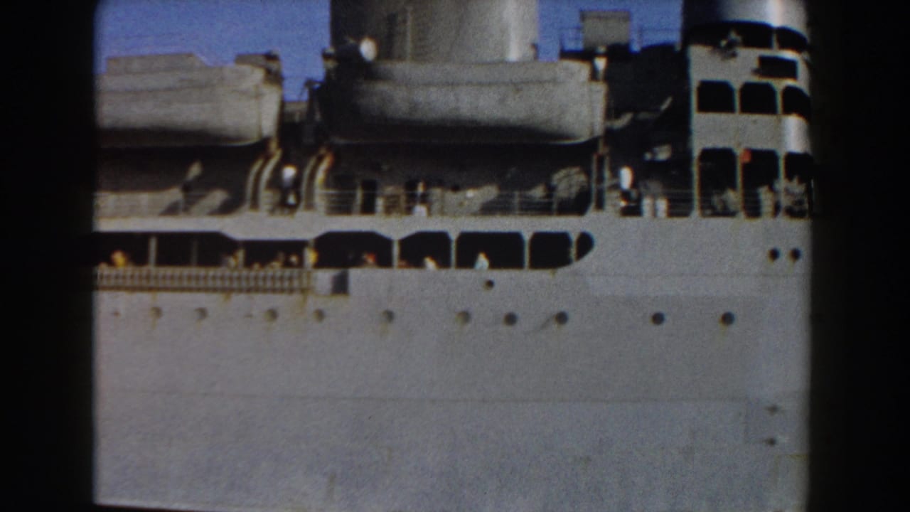 1959 Pisa, Italy footage showing the upper side of a grey naval ship with crew figures, deck railings, and funnels.