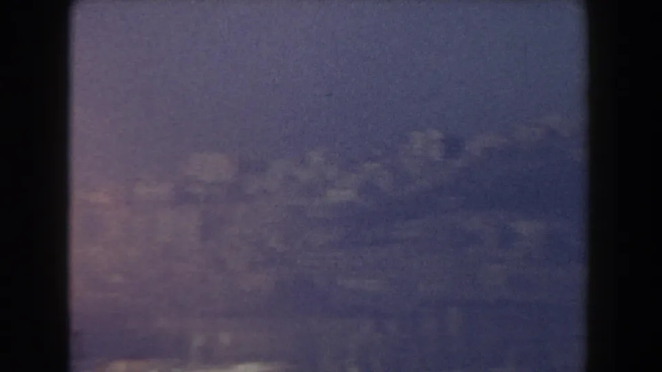 Soft 1959 Pisa, Italy coastal frame with distant waterfront buildings barely visible through faded color and haze.