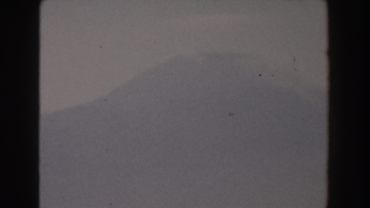 Distant hazy mountain ridge under a pale sky with dark 8mm frame borders.