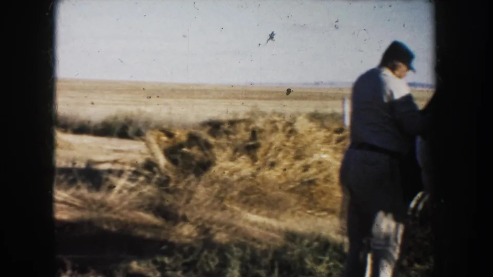 The man remains beside the horse, partly obscured by the animal and dark frame border, with open South Dakota grassland behind them.