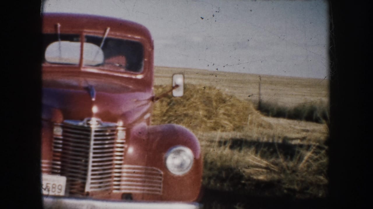 1953 South Dakota 8mm frame showing a red vintage truck front-on in a dry rural field.