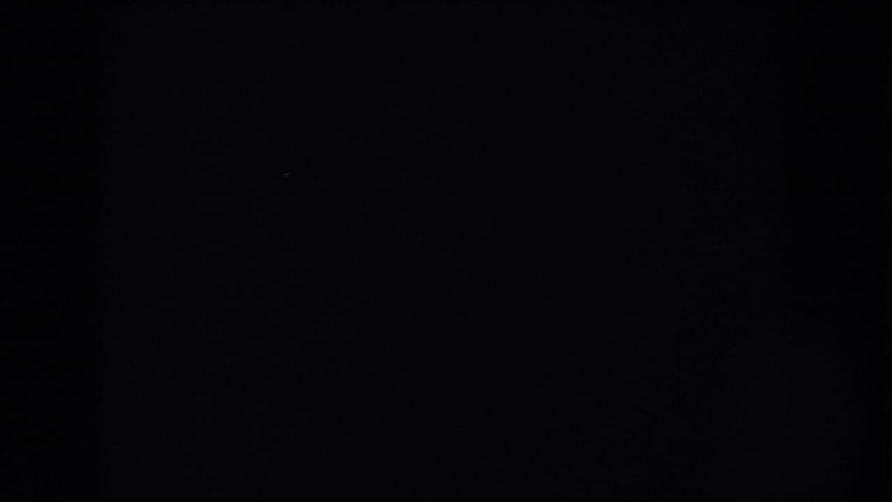 Dark blank 8mm home-movie frame from supplied 1953 South Dakota metadata, with only grain and tiny specks visible.