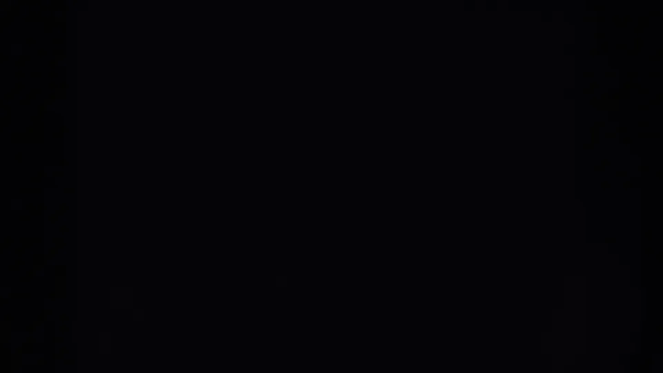 Underexposed 8mm frame with faint texture and no identifiable people or objects visible.