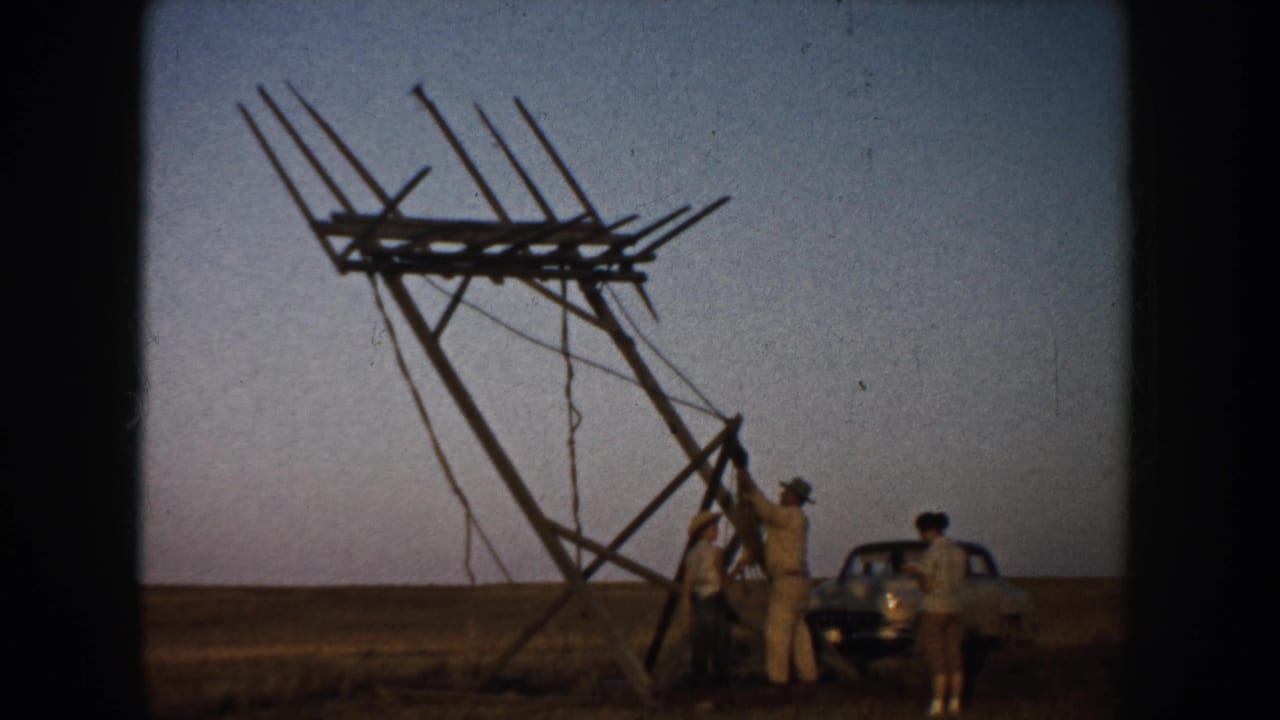 Near the end of the clip, men cluster around the base of the leaning sign frame in the rural South Dakota field with the car beside them.