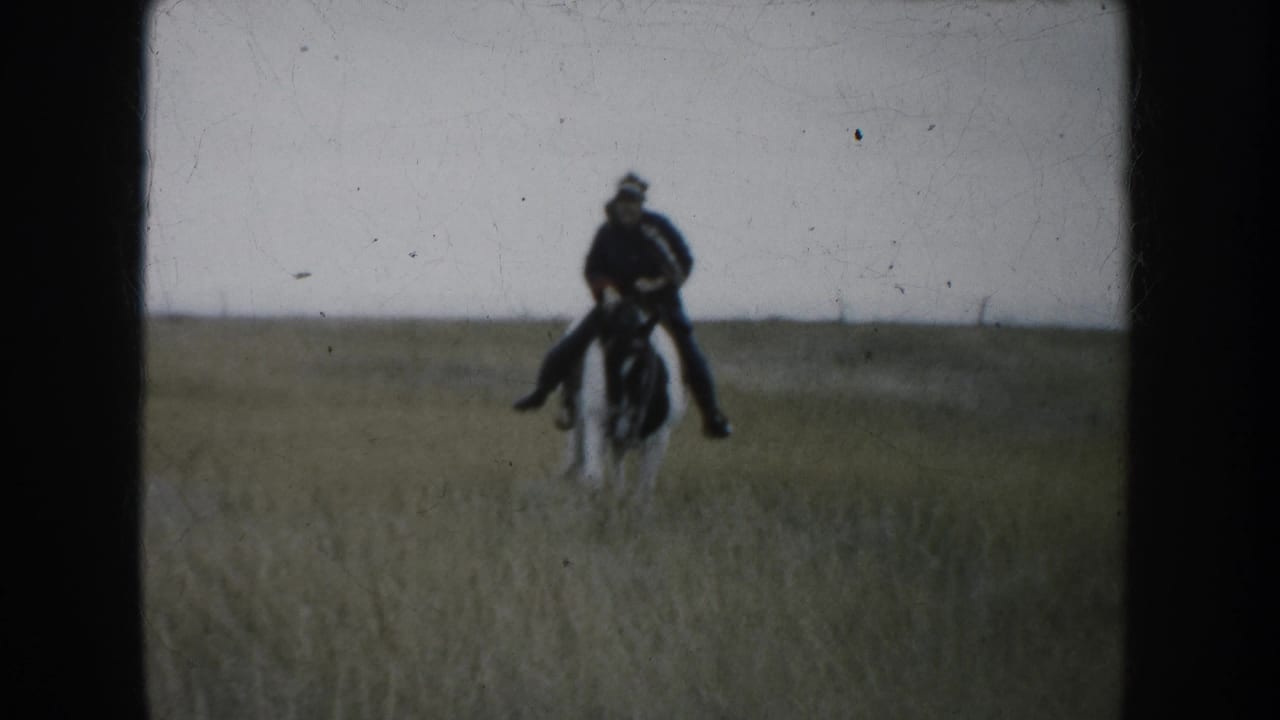 1953 South Dakota 8mm frame showing a rider on horseback in a pasture, filmed from a handheld home-movie viewpoint.
