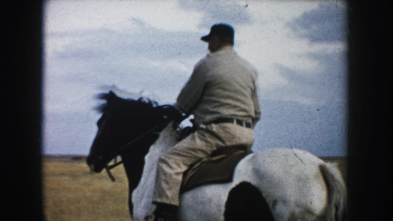 Man riding a brown-and-white horse across open grassland under a cloudy sky.