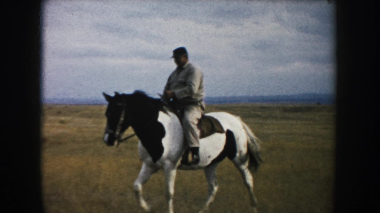 The mounted man continues across a South Dakota prairie on a black-and-white pinto horse, framed by 8mm film borders.