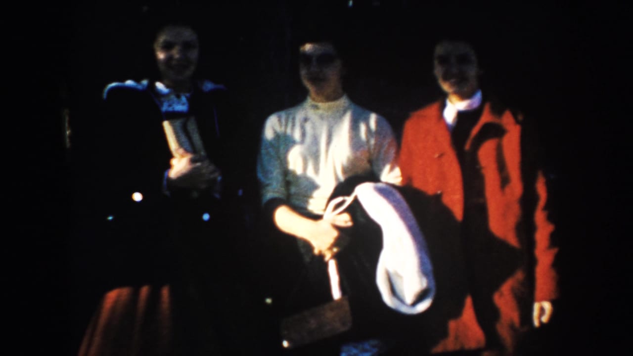Three adult visitors pose in dark shadow and bright sun during a 1953 South Dakota home-movie travel stop.