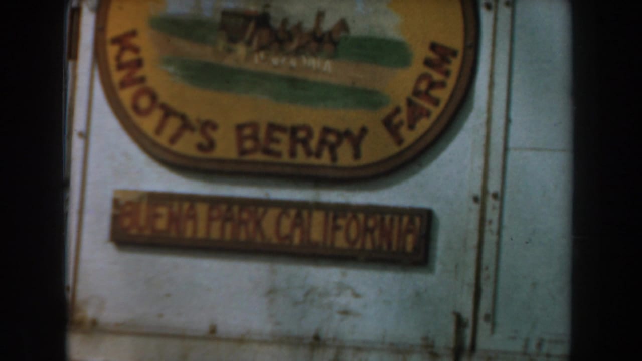 Knott's Berry Farm sign with Anaheim California plaque beside part of a red stagecoach.