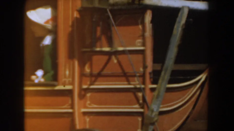 The red Knott's Berry Farm stagecoach fills the frame, with a woman partly visible near the window and carriage straps in front.