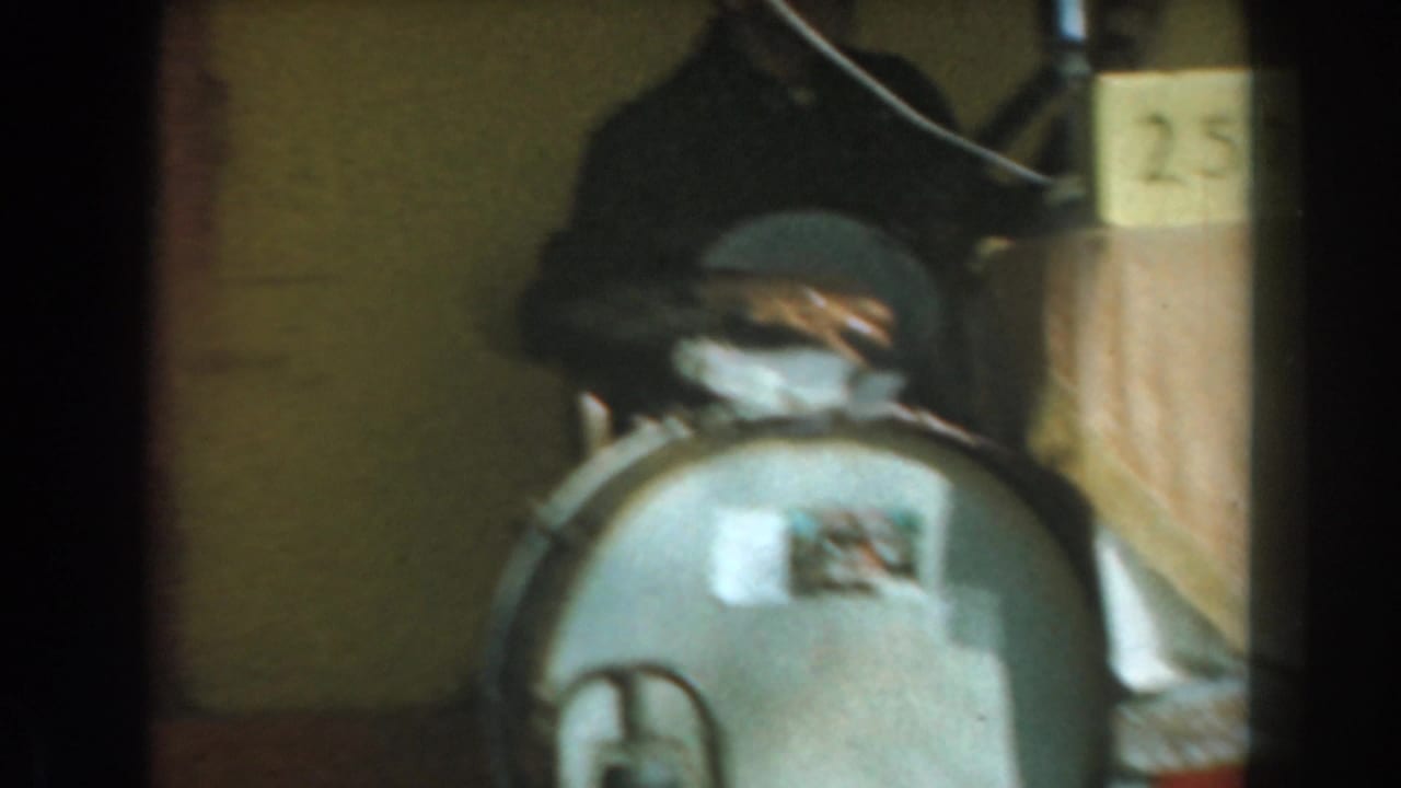 Dim hall view with a round metal object, a person partly hidden behind it, and a box marked 257.