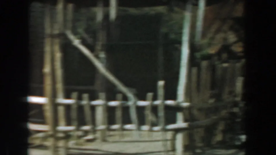 Knott's Berry Farm Old West-style set with rough fencing, vertical posts, angled rail, and weathered wooden structures.