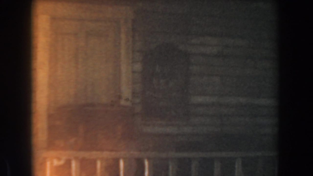 Dim wooden facade with railing and a dark vertical edge in soft focus.