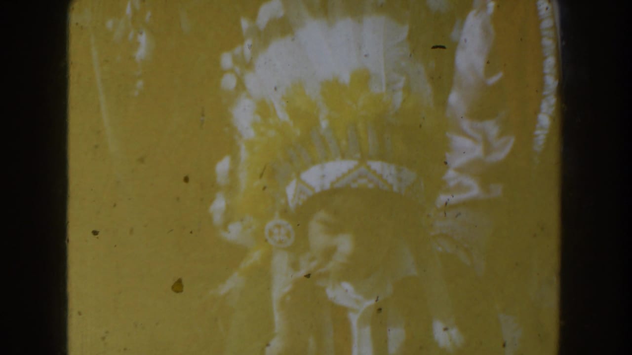 Faded frame with a sea lion attraction partly obscured by warm exposure and film damage.