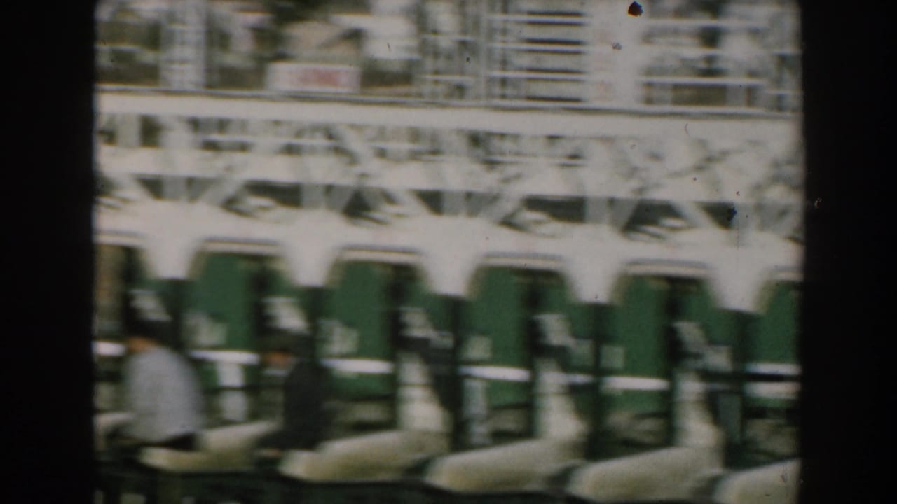 Passengers seated inside a transport area with rows of seats and a Greek-numbered sign.