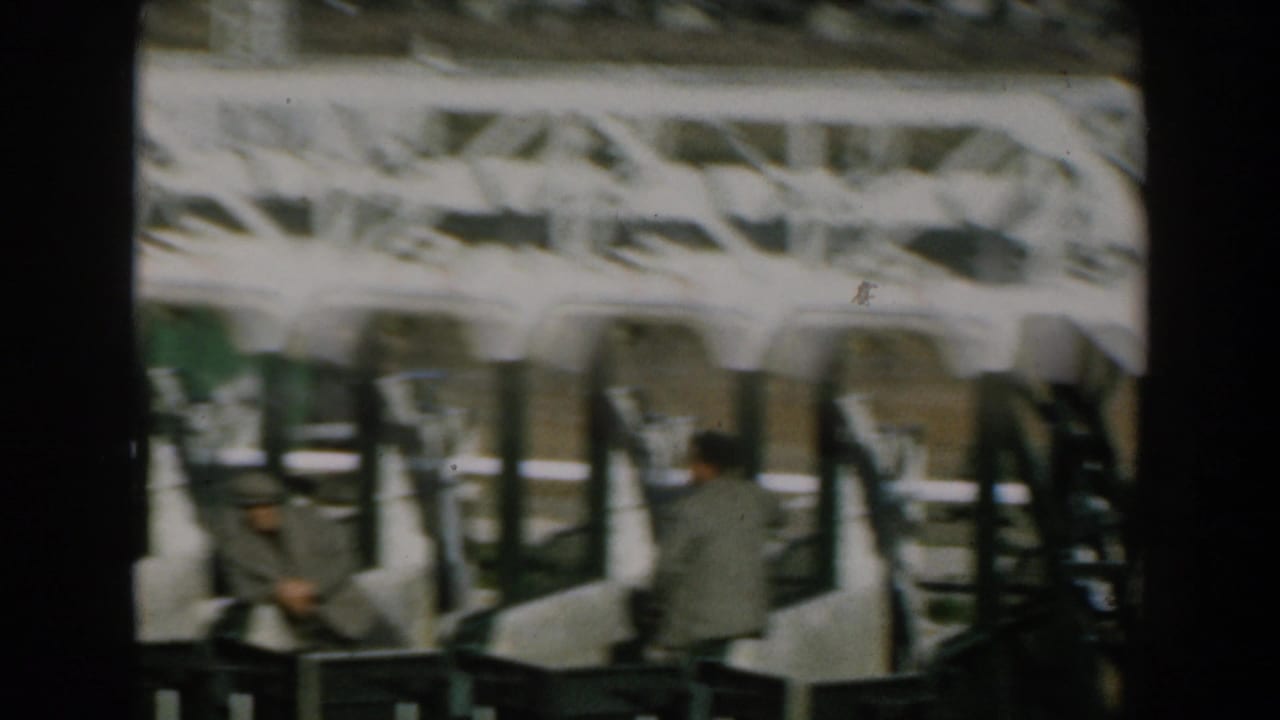 Passengers and standing figures beside rows of seats in a transport or boarding area.
