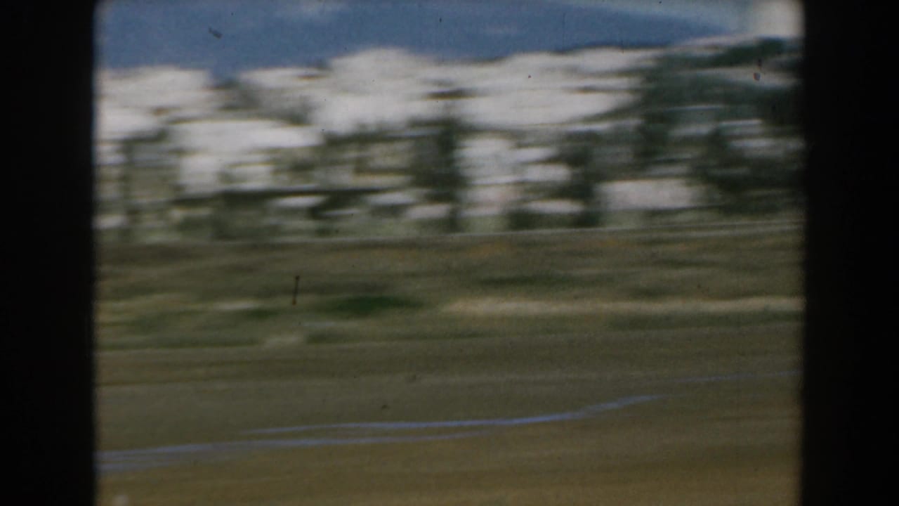 Blurred snowy landscape seen through dark film-frame borders.
