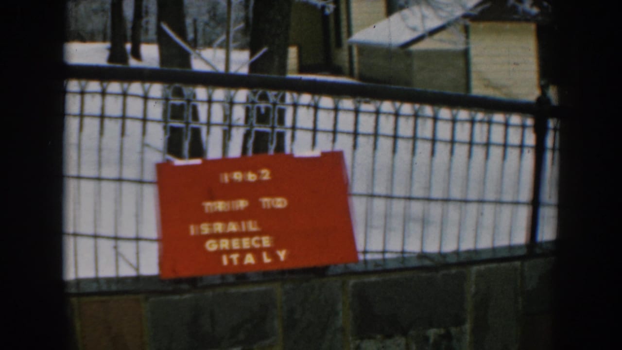 1962 travel title card for Israel, Greece, and Italy shown on a metal grid in an 8mm home-movie frame.