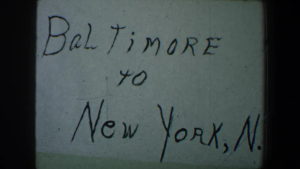 1960 8mm frame of a handwritten travel note where New York, N.Y. is partly near the lower frame edge.