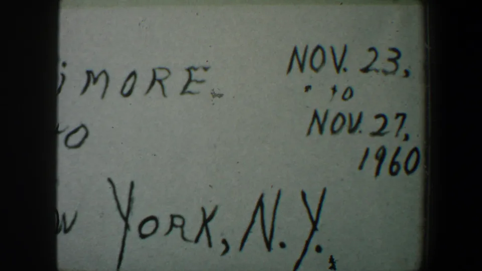 1960 8mm frame of a handwritten Baltimore-to-New York title card, partially cropped with Nov. dates visible.