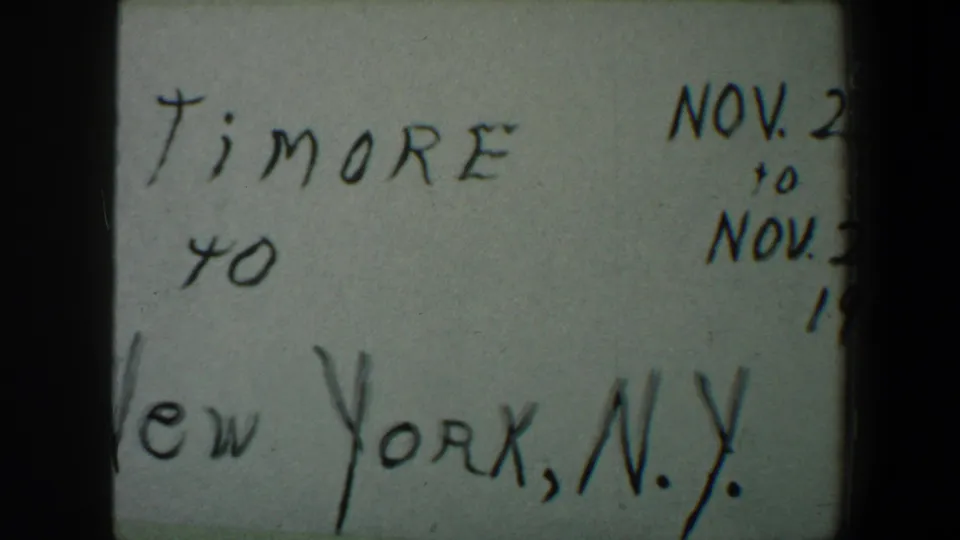 Cropped 1960 home-movie title card with Baltimore to New York, N.Y. written in black ink on white paper.