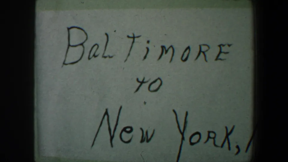 1960 8mm home-movie title card reading Baltimore to New York, N.Y., framed tightly with visible film edges.