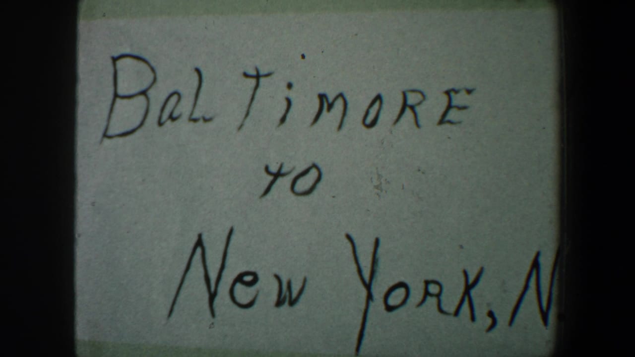 Close 8mm view of the handwritten Baltimore to New York note, with the right side cropped and visible film gate darkness.